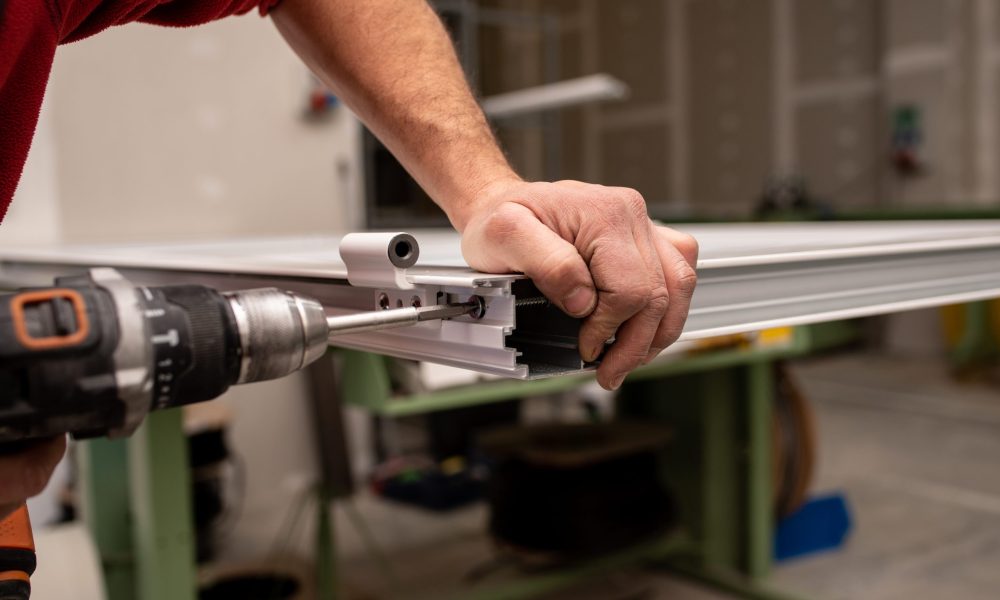 A male with a red shirt making a window with industrial tools