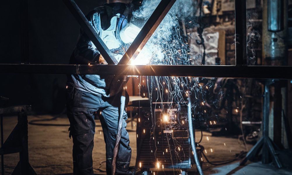 Welding work with metal construction at busy metal factory